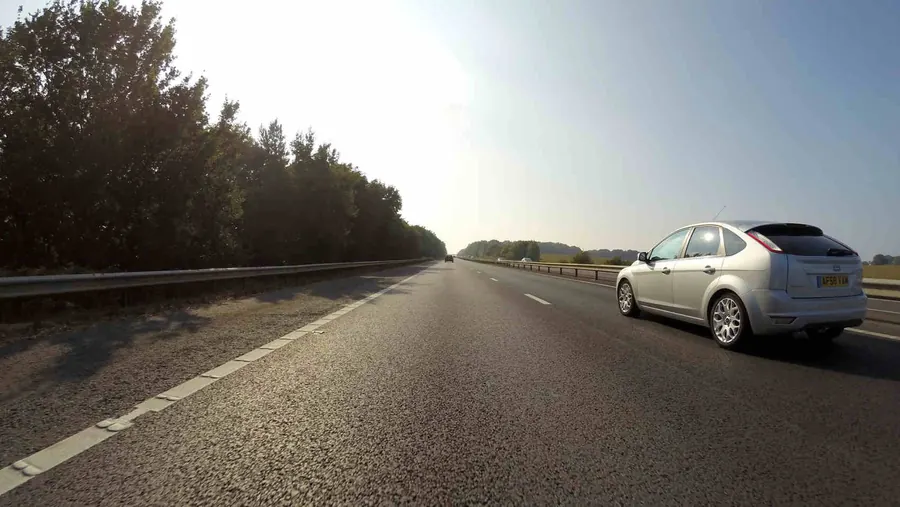 Auto plateado circulando por una ruta